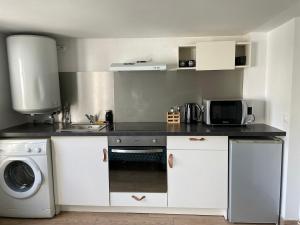 a kitchen with a sink and a washing machine at Elegant studio in Arcueil