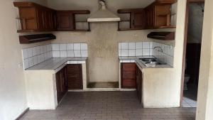 an empty kitchen with wooden cabinets and a sink at Habitaciones económicas in Cuenca