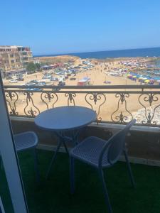a table and chairs on a balcony with a view of the beach at Résidence nissou in Jijel +4 photos