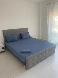 a large bed with blue pillows in a bedroom at Résidence nissou in Jijel