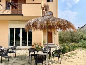 a group of chairs and tables in front of a building at Titi's Villa in Durrës