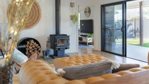 a living room with a couch and a fireplace at Serenity Bay Retreat - Luxury Coastal Living in Emerald Beach