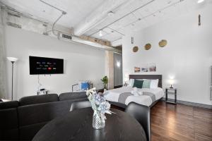 Una sala de estar con un sofá, una cama y una mesa. en Stunning Downtown Apartment with Pool, Laundry, Parking, en Dallas