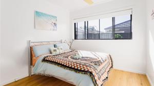 a bedroom with a bed and a window at Serenity Bay Retreat - Luxury Coastal Living in Emerald Beach