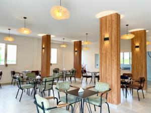a dining room with tables and chairs and lights at Titi's Villa in Durrës
