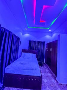 a bedroom with a bed with a neon sign on the ceiling at Elite Retreat Apartment, Ewu Oliwo Sagamu in Sagamu