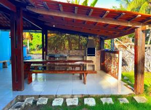 a wooden picnic table under a wooden pergola at Casa Tropical in Marau