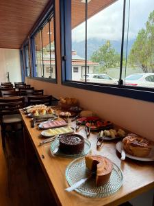 a long table with cakes and other food on it at Pousada Casa Cota in Catas Altas +36 photos