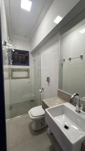 a bathroom with a toilet and a sink and a shower at Pousada Casa Cota in Catas Altas