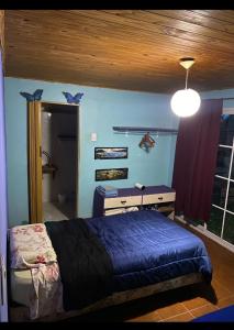 a bedroom with a bed and a desk and a window at La casita in Puerto Iguazú