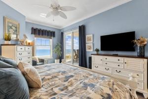 una camera con un grande letto e una TV a schermo piatto di 60 Ocean Place a Fernandina Beach