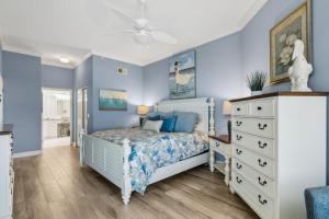 una camera da letto con pareti blu, un letto e una cassettiera di 60 Ocean Place a Fernandina Beach Altre 33 foto