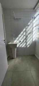 a bathroom with a sink and a shadow on the wall at Espaço Harmonia - um apartamento inteiro e aconchegante para vc! in Curitiba