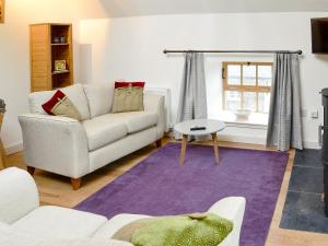 a living room with a couch and a table at The Hayloft in Blitterlees