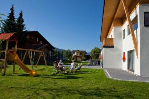 two people sitting in chairs in a yard with a playground at Apartments in Flachau - Salzburger Land 368 in Flachau
