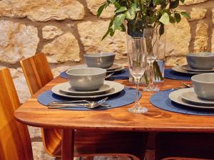 a wooden table with plates and bowls and glasses on it at Alt-Na-Craig in Rothbury