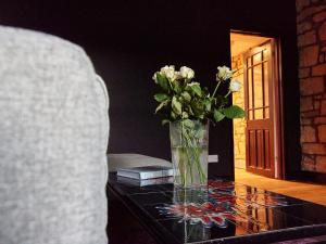 a vase of flowers sitting on a glass table at Alt-Na-Craig in Rothbury