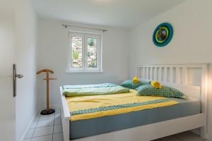 a bedroom with a bed with yellow sheets and a window at Apartments with parking space Vidalici, Pag - 9393 in Kustići