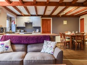 a living room and kitchen with a couch and a table at Trough Cottage - Uk48424 in Holmfirth
