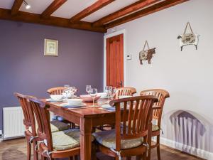 a dining room with a wooden table and chairs at Trough Cottage - Uk48424 in Holmfirth