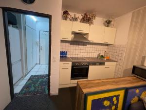 a kitchen with white cabinets and an open door at Panorama building in Eschborn