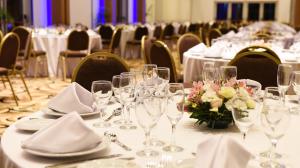 a table with wine glasses and flowers on it at Hotel y Casino Del Río - Cipolletti in Cipolletti