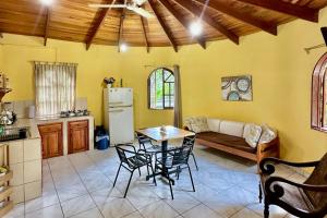 a kitchen and living room with a table and a refrigerator at Hospedaje Colibri in Manuel Antonio