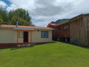 a row of houses in a yard with a grass field at cabañas Don Edilio in El Cerrillo