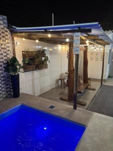 a blue swimming pool in the middle of a room at Hanuá Beach House in Guarapari