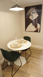 a white table and chairs in a room with a painting at Cosy Leeds City Centre Apartment in Central Station +10 photos