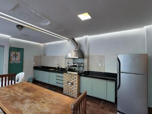 a kitchen with a table and a refrigerator at Casa em condomínio para COP 30 in Belém