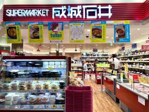 Una tienda con gente en la sección de alimentos de un supermercado. en Generous Forest 101, en Tokio