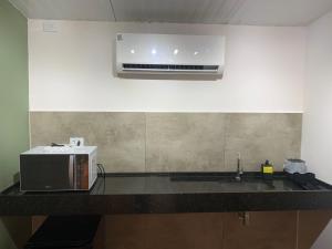 a kitchen with a microwave and a sink at Bangalô 2 Rota do Vinho São Roque in São Roque +16 photos