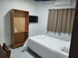 1 dormitorio con 1 cama, armario y TV en Hotel Maringá, en Juara 14 fotos más