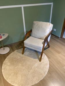 a chair with a white pillow sitting on a rug at Bangalô 2 Rota do Vinho São Roque in São Roque
