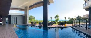 a swimming pool in a building with a view of the ocean at Escape Condominium Mea Pim Beach Rayong in Mae Pim