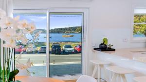 a kitchen with a view of the water and a boat at Ettalong Waterfront Retreat in Ettalong Beach