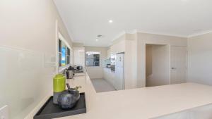 a kitchen with white walls and a counter with a vase at Ettalong Waterfront Retreat in Ettalong Beach