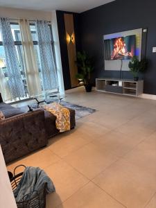 a living room with a couch and a flat screen tv at One Love Escape & Tours in Kingston