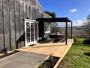 a patio with a table and a gazebo at Hurstmere Cottage, Matakana in Matakana