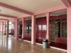 an empty building with pink walls and a trash can at Hotel Carollina Syariah in Girijati
