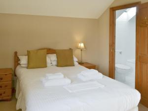 a bedroom with a white bed with towels on it at Ferguson in Warenford