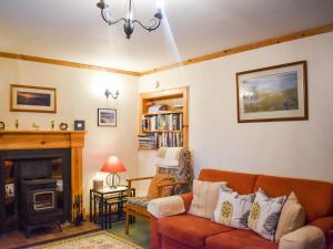 un salon avec un canapé et une cheminée dans l'établissement The Cottage, à Ollach