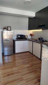 a kitchen with a refrigerator and a wooden floor at Las Palmas Apart in Tacna +7 photos