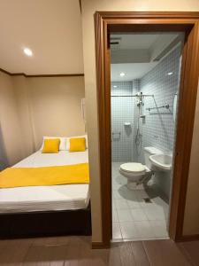 a bedroom with a bed and a shower and a toilet at Subic Bay Baloy Long Beach Hotel in Olongapo