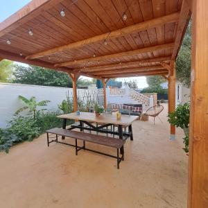a picnic table and bench under a wooden pergola at Buganvilla in Valencia