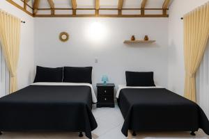 two beds sitting next to each other in a room at Cabaña familiar con 4 dormitorios y baños privados in Villa de Leyva