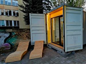 two chairs are sitting next to a tiny house at Apartament Contandair in Olsztyn