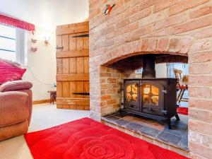 a brick fireplace in a living room with a fire place at The Old Vicarage in Stowe