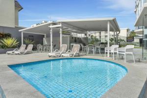 una piscina con sedie e tavolo e un edificio di Catalina Resort a Maroochydore Altre 31 foto